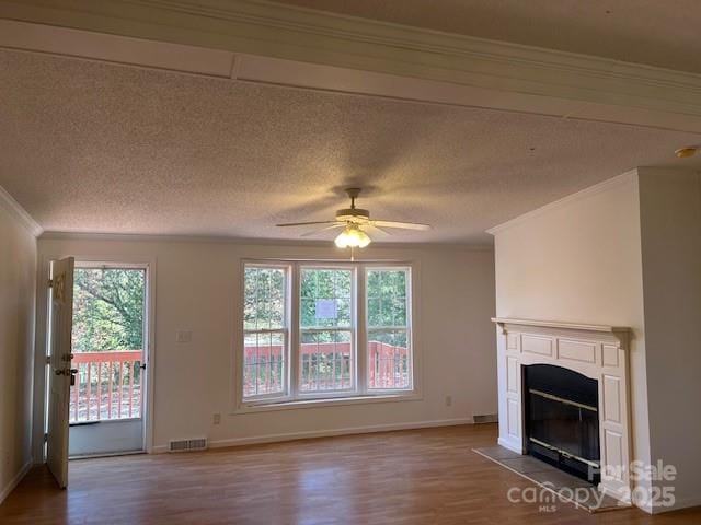 unfurnished living room featuring ceiling fan, crown molding, and a healthy amount of sunlight