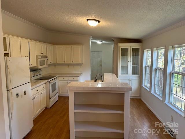 kitchen featuring white appliances, dark wood-type flooring, a textured ceiling, tile counters, and white cabinets