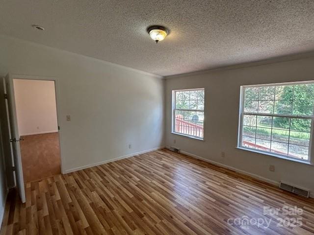 spare room featuring a textured ceiling and hardwood / wood-style flooring