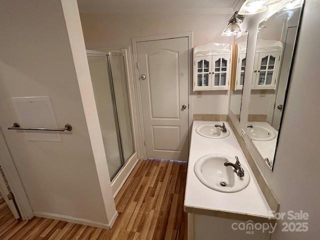 bathroom featuring hardwood / wood-style flooring, an enclosed shower, and vanity