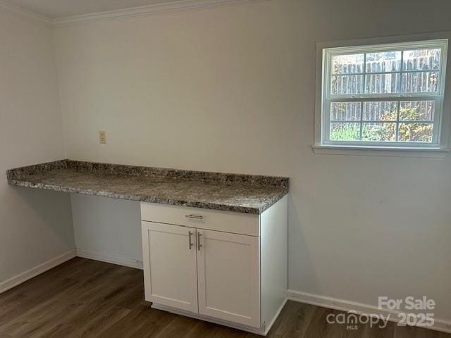 laundry area with ornamental molding and dark wood-type flooring