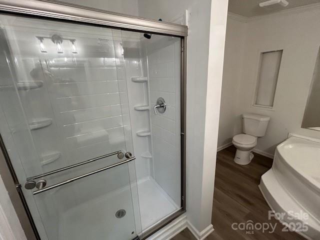 bathroom with walk in shower, hardwood / wood-style floors, crown molding, and toilet