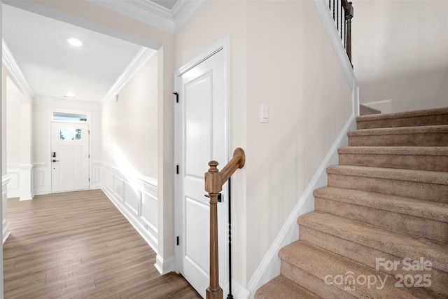 stairway featuring crown molding and hardwood / wood-style floors