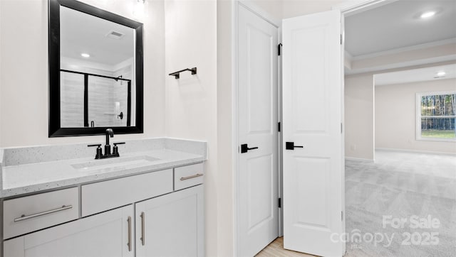 bathroom featuring ornamental molding, a shower with door, and vanity