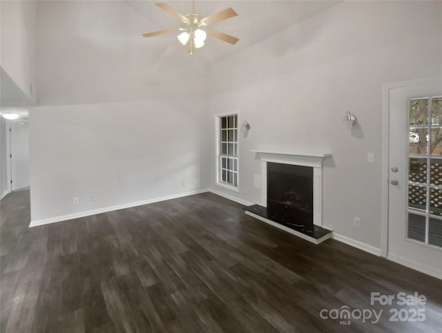 unfurnished living room featuring dark wood-type flooring, high vaulted ceiling, and ceiling fan