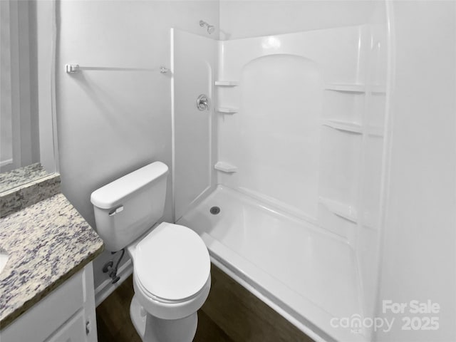 bathroom with walk in shower, vanity, and toilet