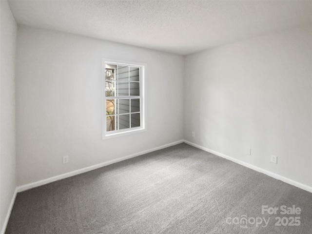 carpeted spare room featuring a textured ceiling