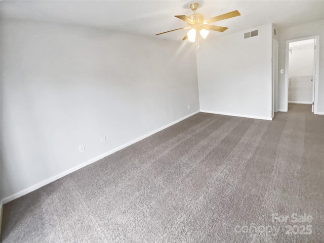 spare room featuring ceiling fan and dark carpet