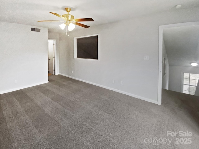 unfurnished room with ceiling fan and dark colored carpet