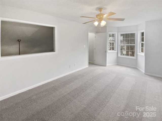 carpeted spare room featuring ceiling fan