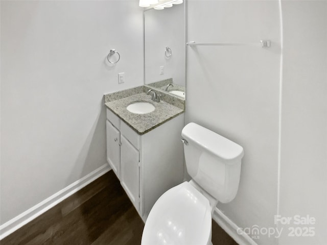 bathroom featuring hardwood / wood-style floors, vanity, and toilet