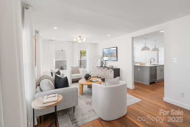 living room with light hardwood / wood-style floors and sink