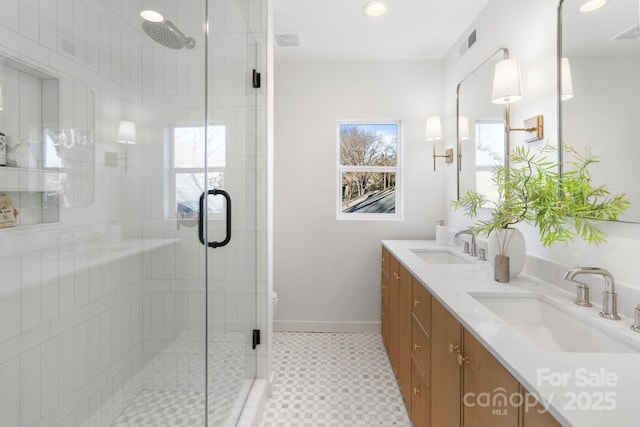 bathroom featuring toilet, a shower with shower door, and vanity