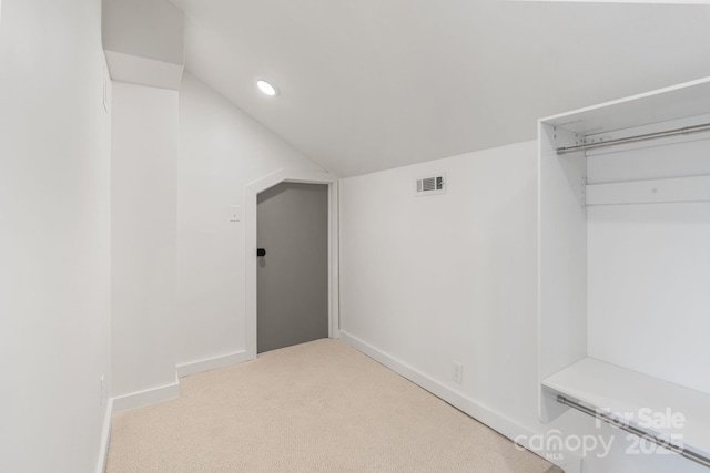 interior space with lofted ceiling and light carpet