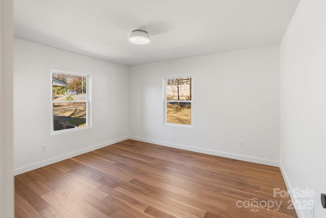 empty room featuring plenty of natural light and hardwood / wood-style floors