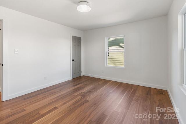 empty room with hardwood / wood-style flooring