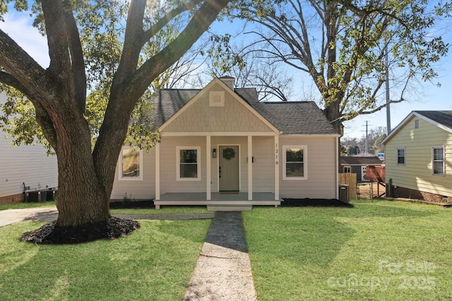 view of front of home featuring a front lawn, a porch, and central AC