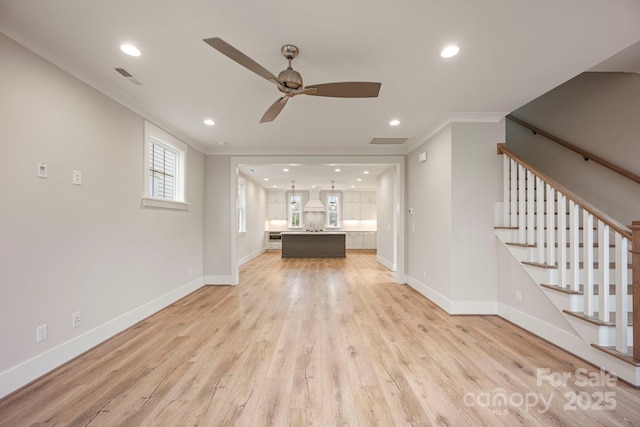 unfurnished living room featuring visible vents, stairs, light wood-type flooring, and ornamental molding