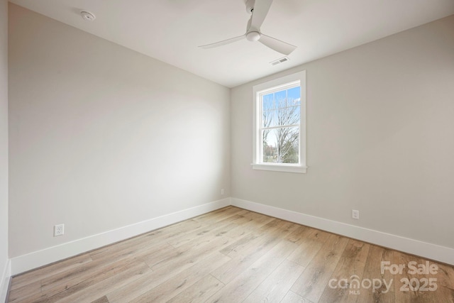 spare room featuring visible vents, baseboards, wood finished floors, and a ceiling fan