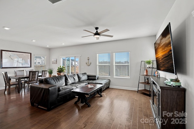 living room with ceiling fan, dark wood-type flooring, and a healthy amount of sunlight