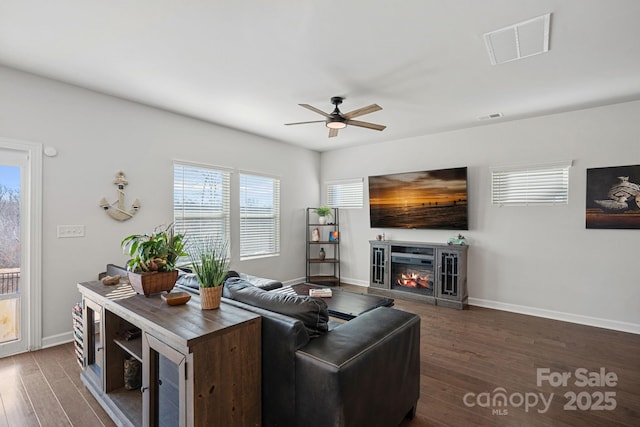 living room with ceiling fan and dark hardwood / wood-style flooring