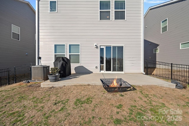 back of property with an outdoor fire pit, a yard, a patio, and central AC