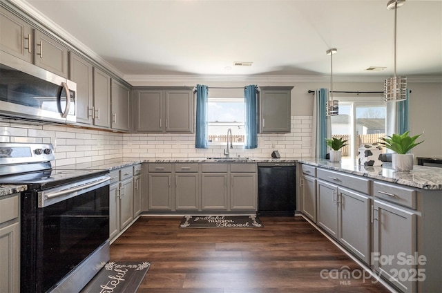 kitchen featuring sink, light stone counters, hanging light fixtures, appliances with stainless steel finishes, and gray cabinets