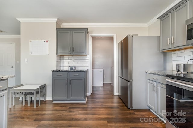 kitchen featuring ornamental molding, appliances with stainless steel finishes, gray cabinetry, and dark hardwood / wood-style flooring