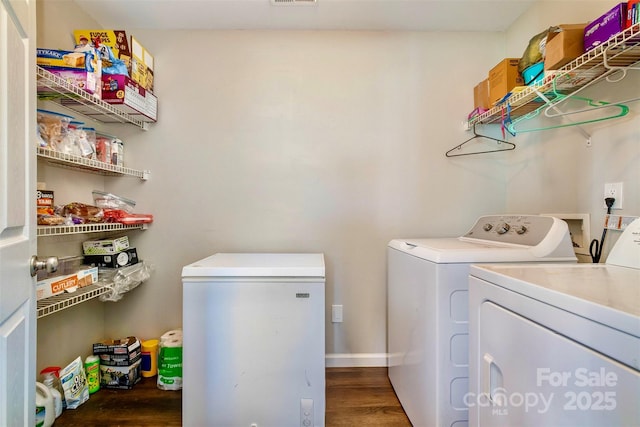 washroom featuring dark hardwood / wood-style floors and washer and clothes dryer