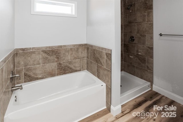 bathroom with hardwood / wood-style flooring and independent shower and bath