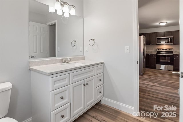 bathroom featuring toilet, wood-type flooring, and vanity