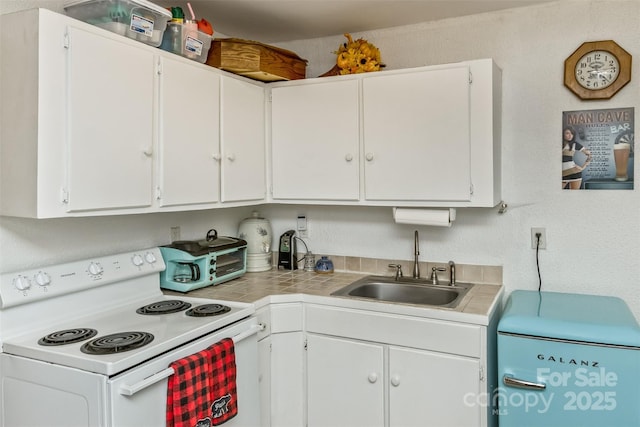 kitchen with sink, white range with electric cooktop, and white cabinetry