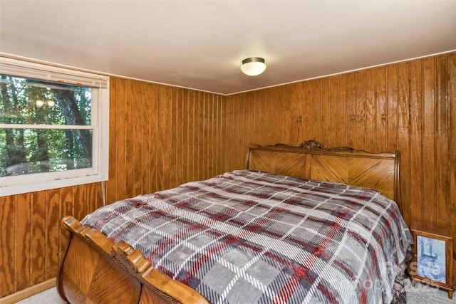 carpeted bedroom with wooden walls