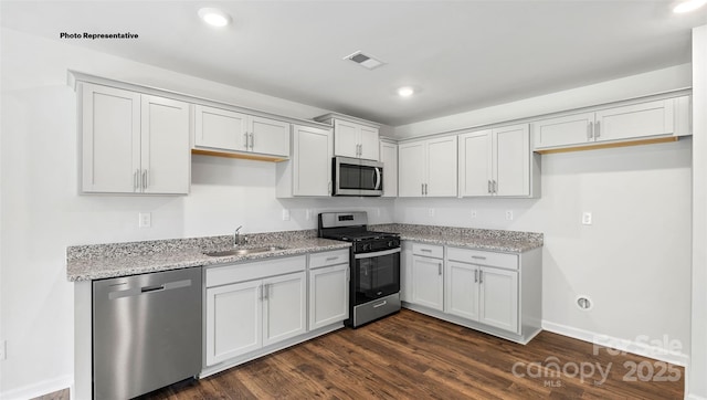 kitchen featuring light stone counters, sink, white cabinetry, and stainless steel appliances