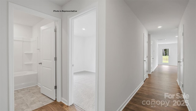 hallway featuring light colored carpet