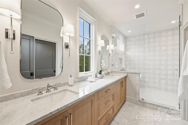 bathroom featuring a tile shower, ornamental molding, a wealth of natural light, and vanity