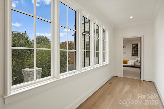 interior space with crown molding and light hardwood / wood-style flooring