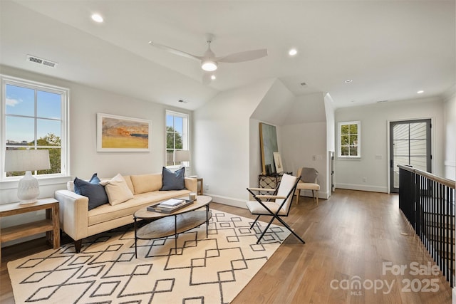 living room featuring ceiling fan, light hardwood / wood-style flooring, and vaulted ceiling