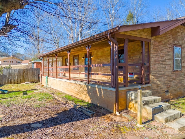 view of side of home featuring covered porch