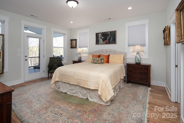 bedroom with hardwood / wood-style floors and access to exterior