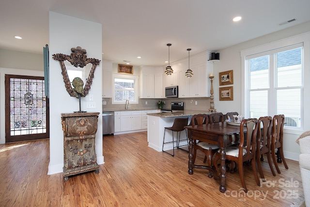 dining space featuring sink and light hardwood / wood-style floors