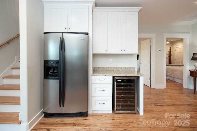 kitchen with beverage cooler, white cabinets, and stainless steel refrigerator with ice dispenser