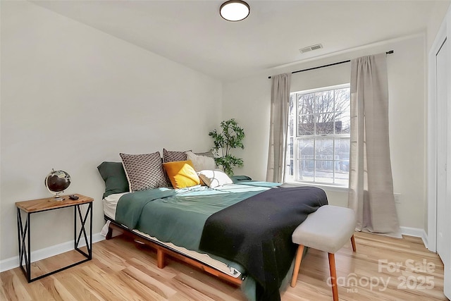 bedroom featuring multiple windows and wood-type flooring