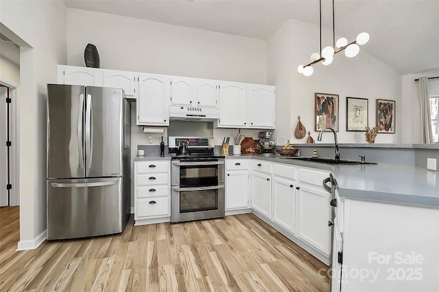 kitchen featuring pendant lighting, stainless steel appliances, sink, and white cabinets