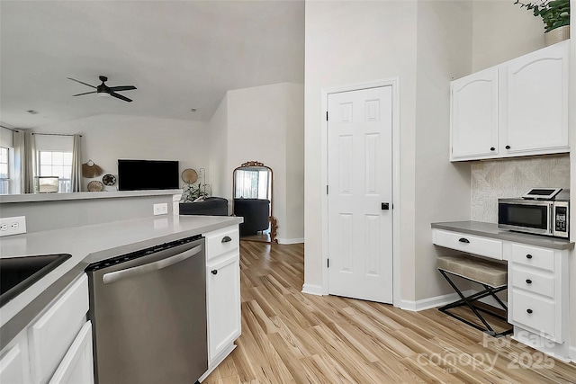 kitchen featuring lofted ceiling, light wood-type flooring, appliances with stainless steel finishes, ceiling fan, and white cabinets