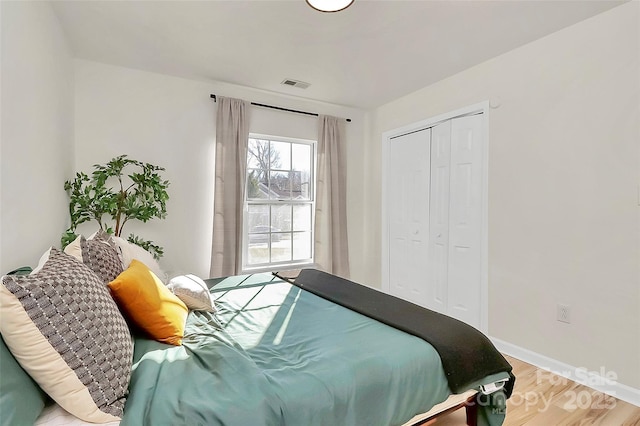 bedroom with hardwood / wood-style floors and a closet