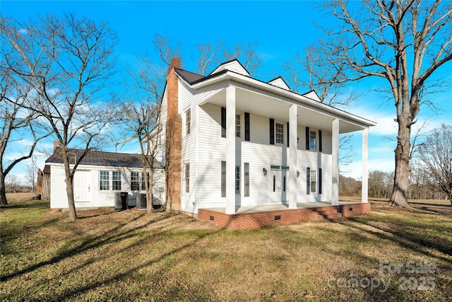 view of front of home with central air condition unit, covered porch, and a front yard