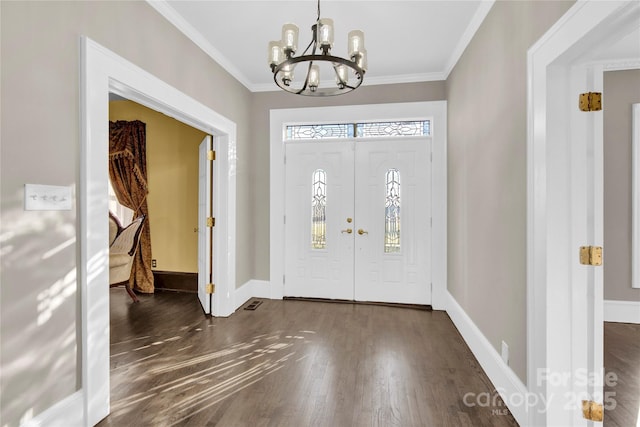 entryway with dark hardwood / wood-style floors, crown molding, and a chandelier