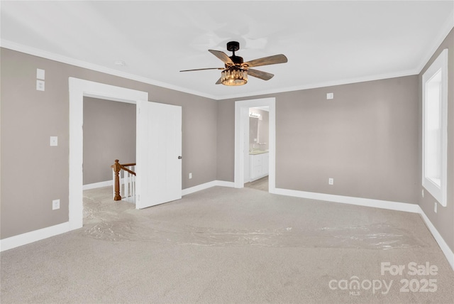 carpeted spare room with ceiling fan, plenty of natural light, and crown molding