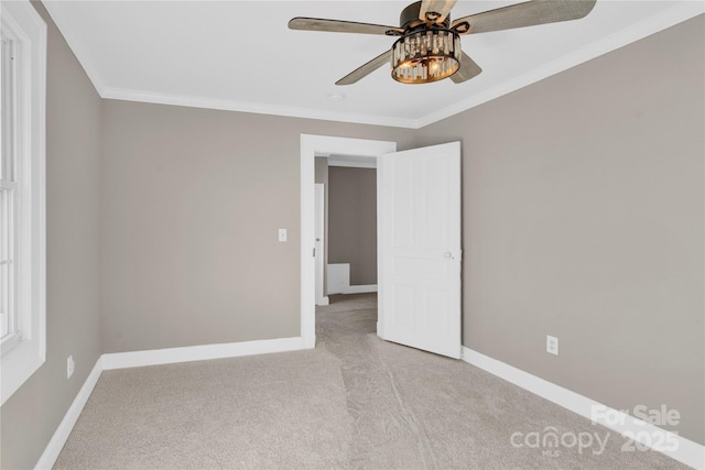 carpeted spare room with ceiling fan and crown molding